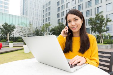 cep telefonu ve dizüstü bilgisayar kullanarak kadın konuşmak