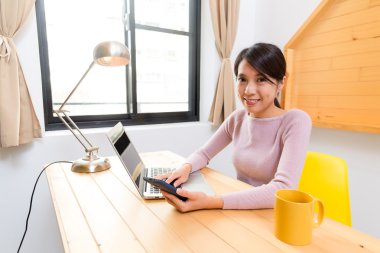 Asyalı kadın dizüstü bilgisayar ve cep telefonu kullanma