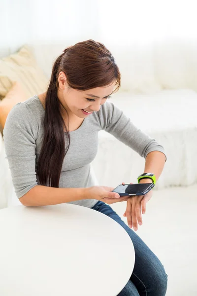 Woman connecting with smartphone and wearable watch — Stock Photo, Image