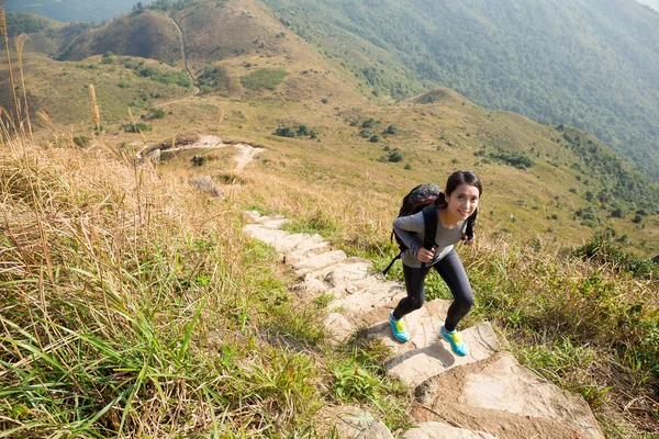 Leende kvinna vandring i bergen — Stockfoto