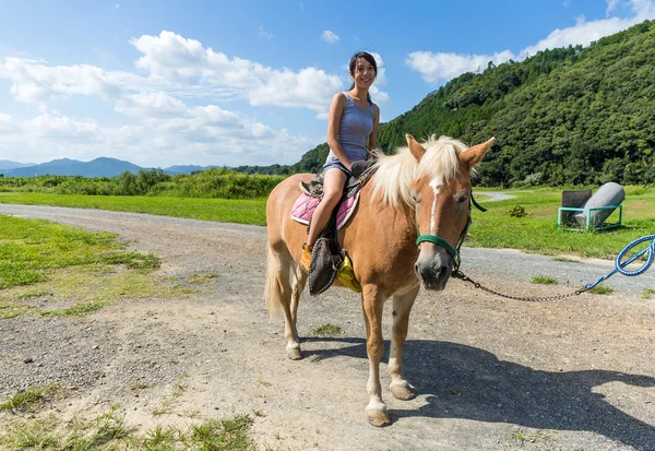Donna che cavalca un cavallo in fattoria — Foto Stock