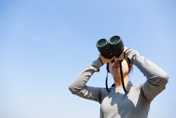 Vrouw op zoek door middel van verrekijkers in de open lucht — Stockfoto