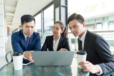 bir dizüstü bilgisayarda tartışırken iş adamları