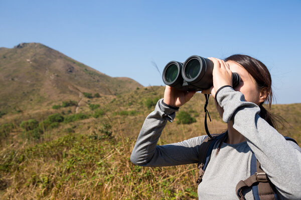 Asian woman looking through binoculars