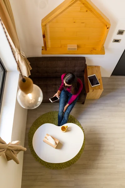 Mujer usando teléfono móvil en casa — Foto de Stock