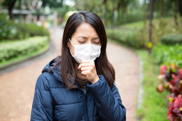 Asian woman sick and wearing face mask