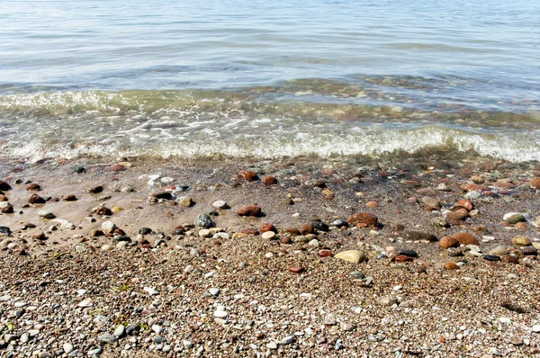 ラトビア。波は、海岸で美しい小石を洗う. — ストック写真