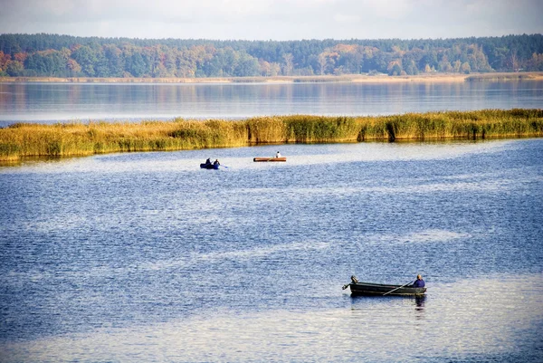 Fishing in the fall by boats on the lake