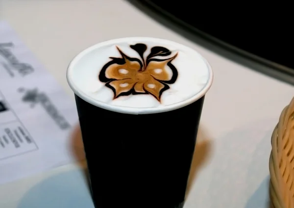 Glass of coffee of a cappuccino with the drawing executed on a s — Stock Photo, Image