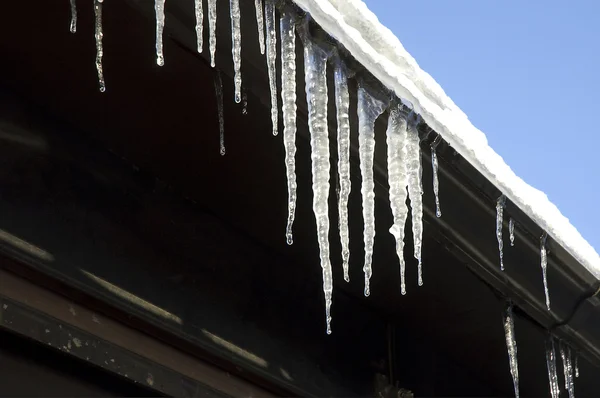 Iicicles on a house roof thaw on the sun — Stock Photo, Image