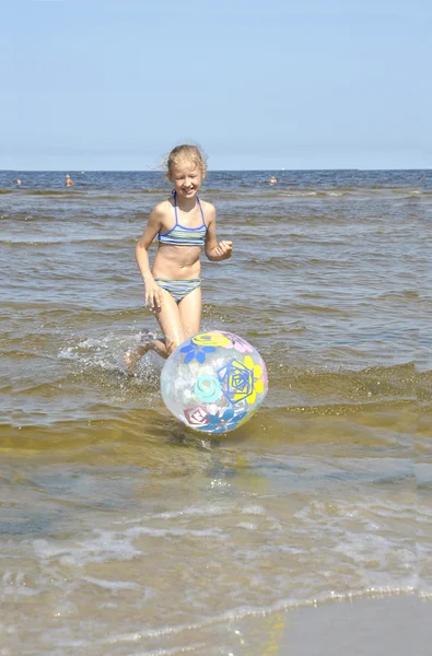 Letland. Het meisje speelt met een bal op Zeekust — Stockfoto