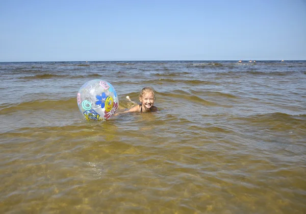 ユールマラ、ラトビア。ボールを持つ少女が海で泳ぐ. — ストック写真