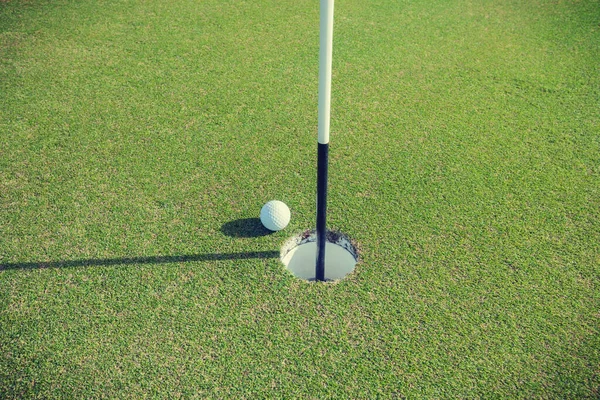 人把高尔夫球放在高尔夫球场上的剪影 — 图库照片