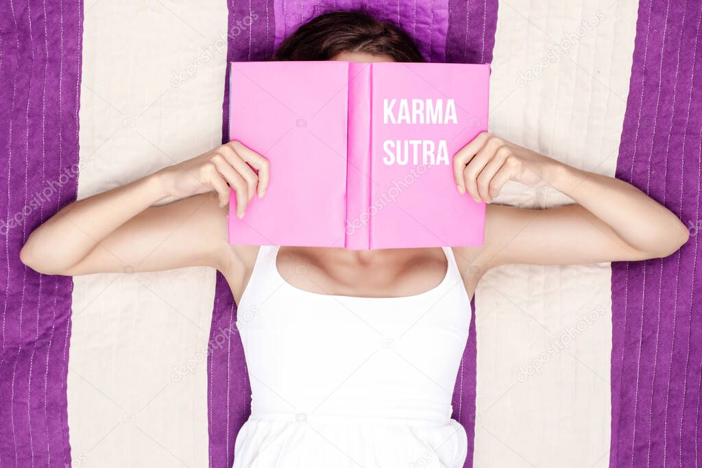 Woman reading a purple book saying karma sutra