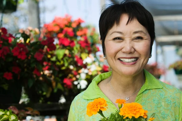 Sorrindo Mulher Chinesa Meia Idade Segurando Flores — Fotografia de Stock