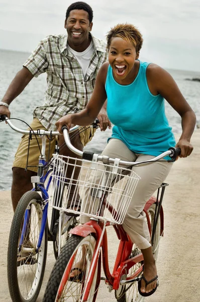 海岸で自転車に乗るアフリカ系アメリカ人のカップルの写真 — ストック写真