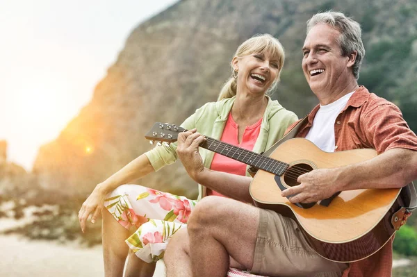 Mężczyzna Gra Gitarze Dla Swojej Żony Plaży Rozbłyskiem Soczewki — Zdjęcie stockowe