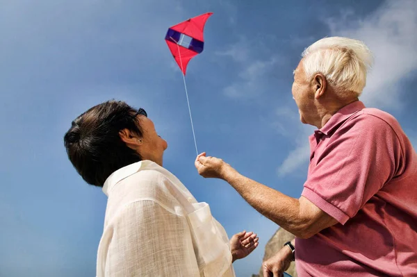 Photo Old Couple Flying Kite Together — Stock Photo, Image