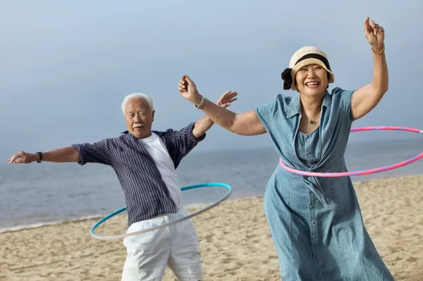 Photo Middle Aged Chinese Couple Hula Hooping Beach — Stock Photo, Image