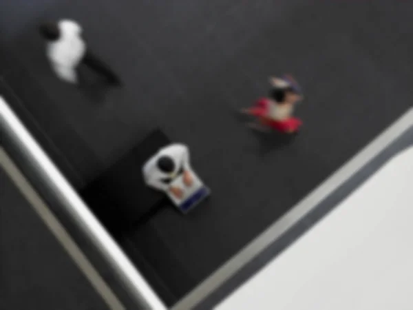 廊下を歩く人々とノートパソコンを使用したビジネスマンの高い角度のビュー — ストック写真