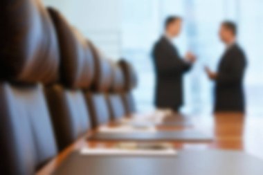 Blurred photo of businessmen talking in conference room clipart