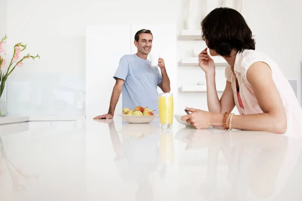 中年夫妇在厨房长椅上吃早餐 — 图库照片