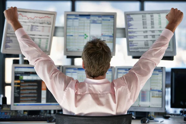 コンピュータ画面を見ながら株式トレーダーを祝うの背面ビュー — ストック写真