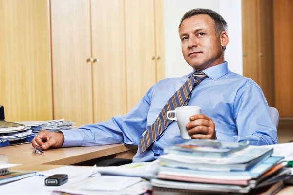 オフィスの机の上にコーヒーを飲むビジネスマンの肖像 — ストック写真
