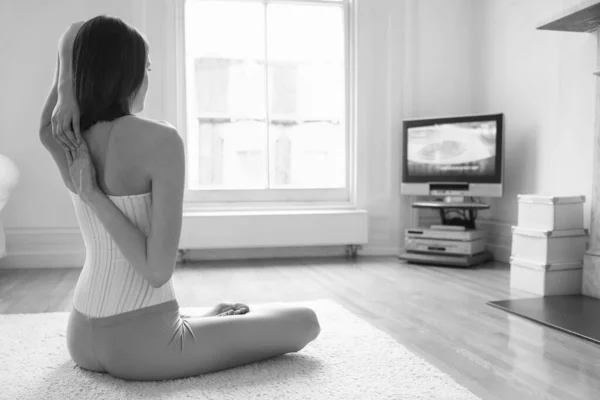 Foto Preto Branco Uma Mulher Esticando Braços Enquanto Assiste Televisão — Fotografia de Stock