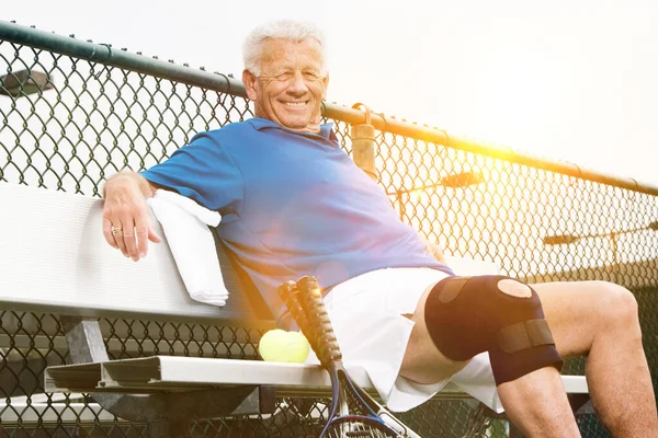 在网球场上戴膝带的男人 — 图库照片