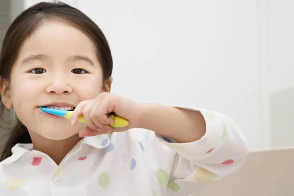 一个年轻女孩刷牙的画像 图库图片