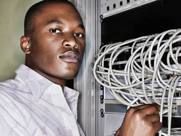 在服务器室工作的非洲技师的画像 图库照片