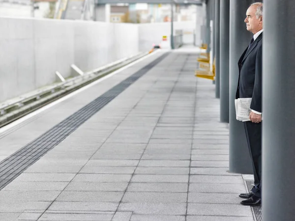 鉄道駅で待っている成熟した実業家 — ストック写真