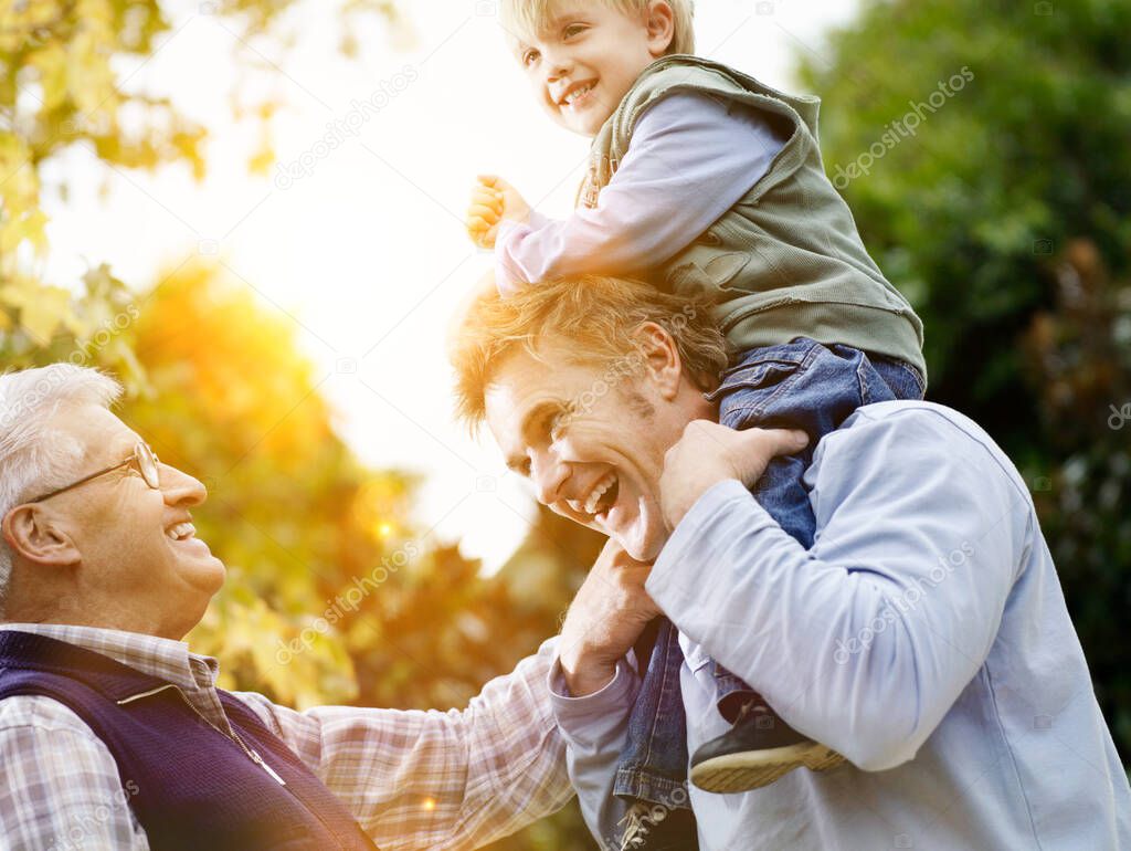 Young boy with father and grandfather enjoying together in park