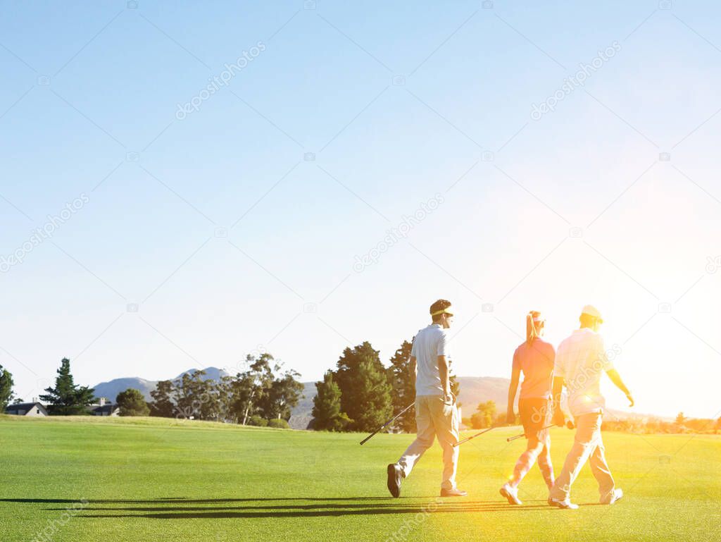 Portrait of young golfers walking on the golf course