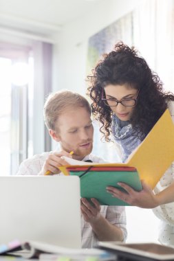 Dosya üzerinde tartışırken iş arkadaşları