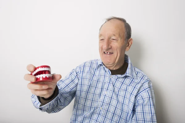 Homme tenant une prothèse dentaire — Photo