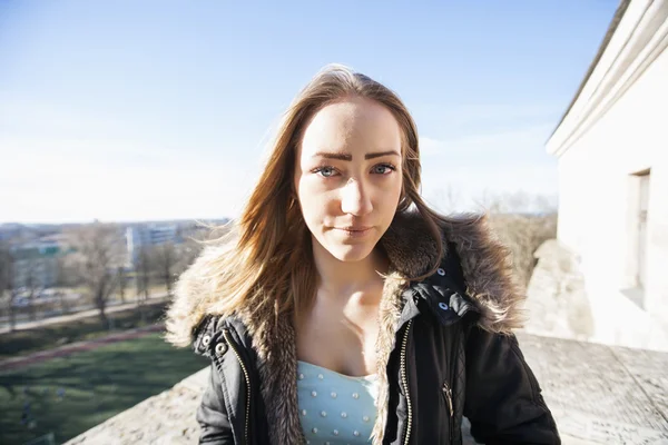 Girl in jacket standing outdoors — Stock Photo, Image