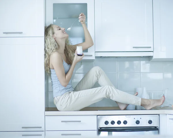 Jovem mulher comendo iogurte — Fotografia de Stock