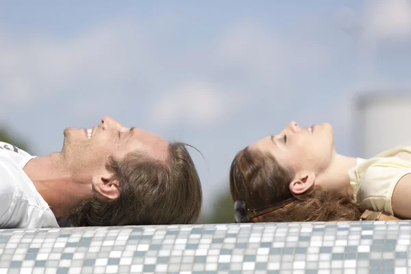 Couple relaxing on mosaic wall — Stock Photo, Image