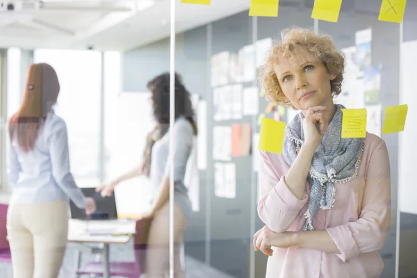 Business woman reading sticky notes — стоковое фото