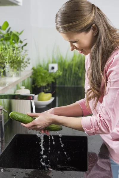 Woman washing cucumber — Stock Photo, Image