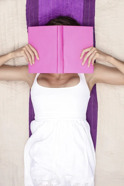 Женщина закрывает лицо книгой — стоковое фото