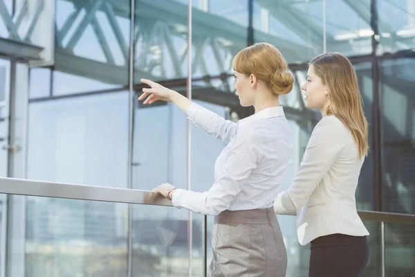 Businesswoman showing something to female colleague — Stock Photo, Image