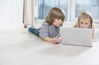 erkek ve kız kardeş dizüstü bilgisayar kullanıyor