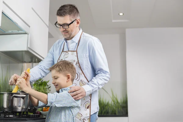 Far och son förbereda spaghetti — Stockfoto