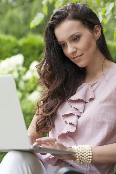 Kobieta korzysta z laptopa w parku — Zdjęcie stockowe