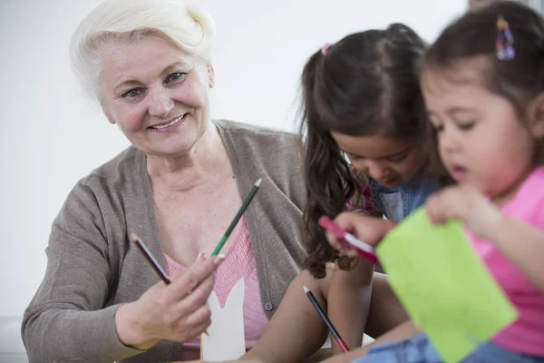 Vrouw helpen kleindochters — Stockfoto