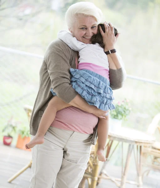 Grandmother carrying granddaughter — Stock Photo, Image