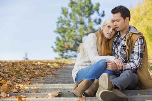 Couple sitting on park steps — Stock Photo, Image